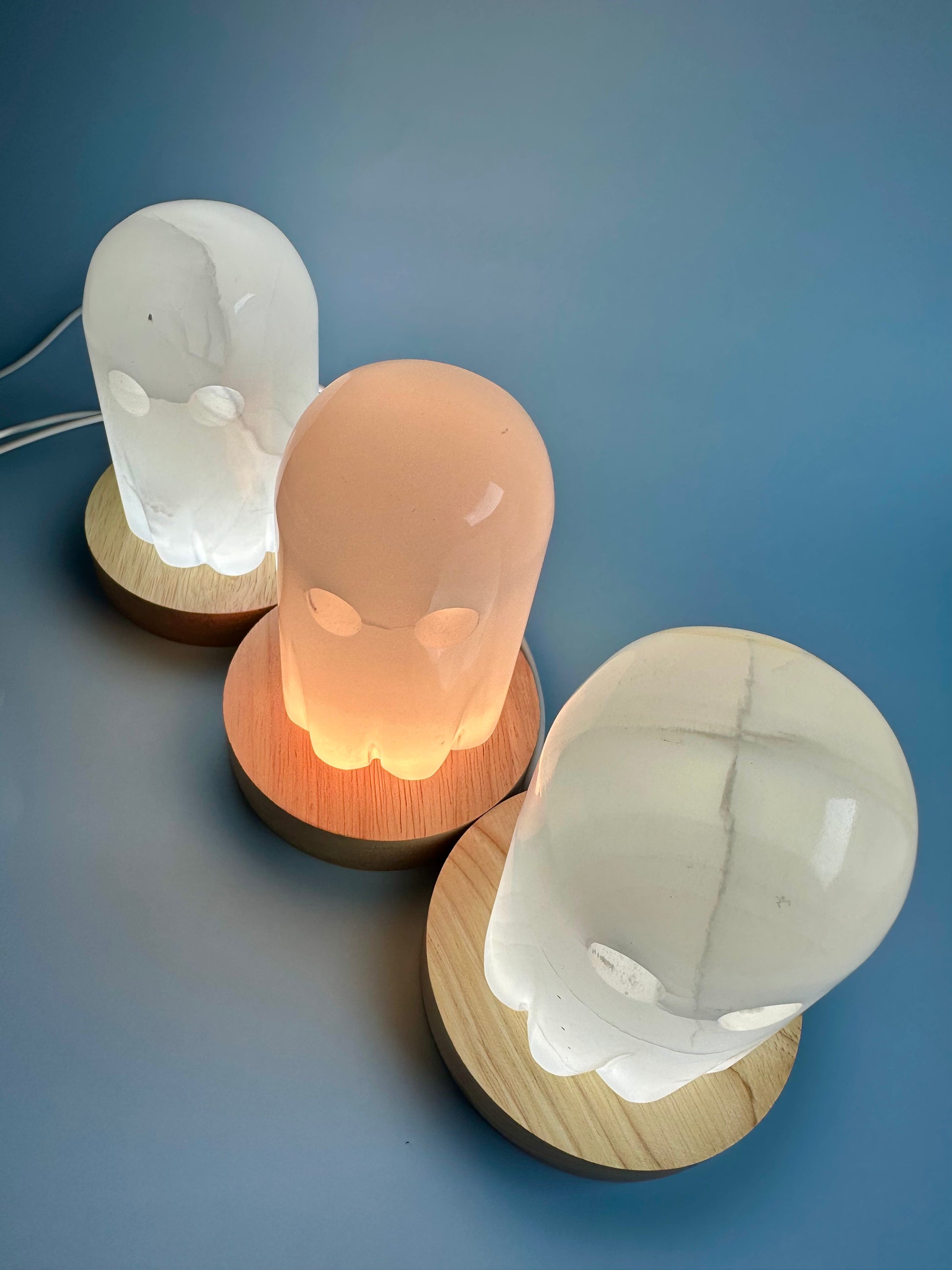 Three decorative lamps with wooden bases on a blue background

